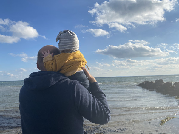 vader met kind staren naar de zee 600px