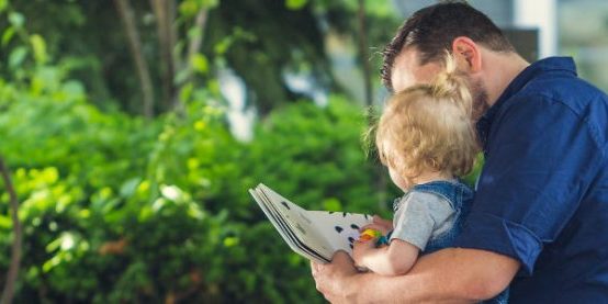 Vader met partnerverlof leest zijn kind voor